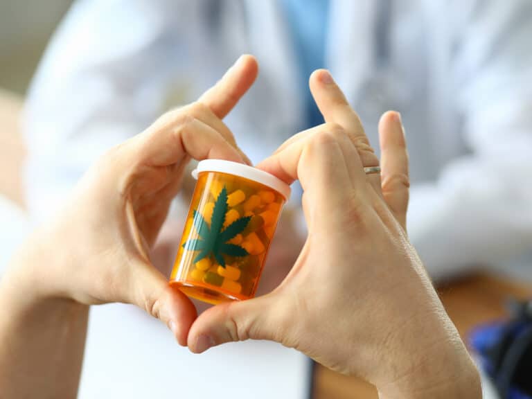 person holding medical marijuana pills with hands in heart shape